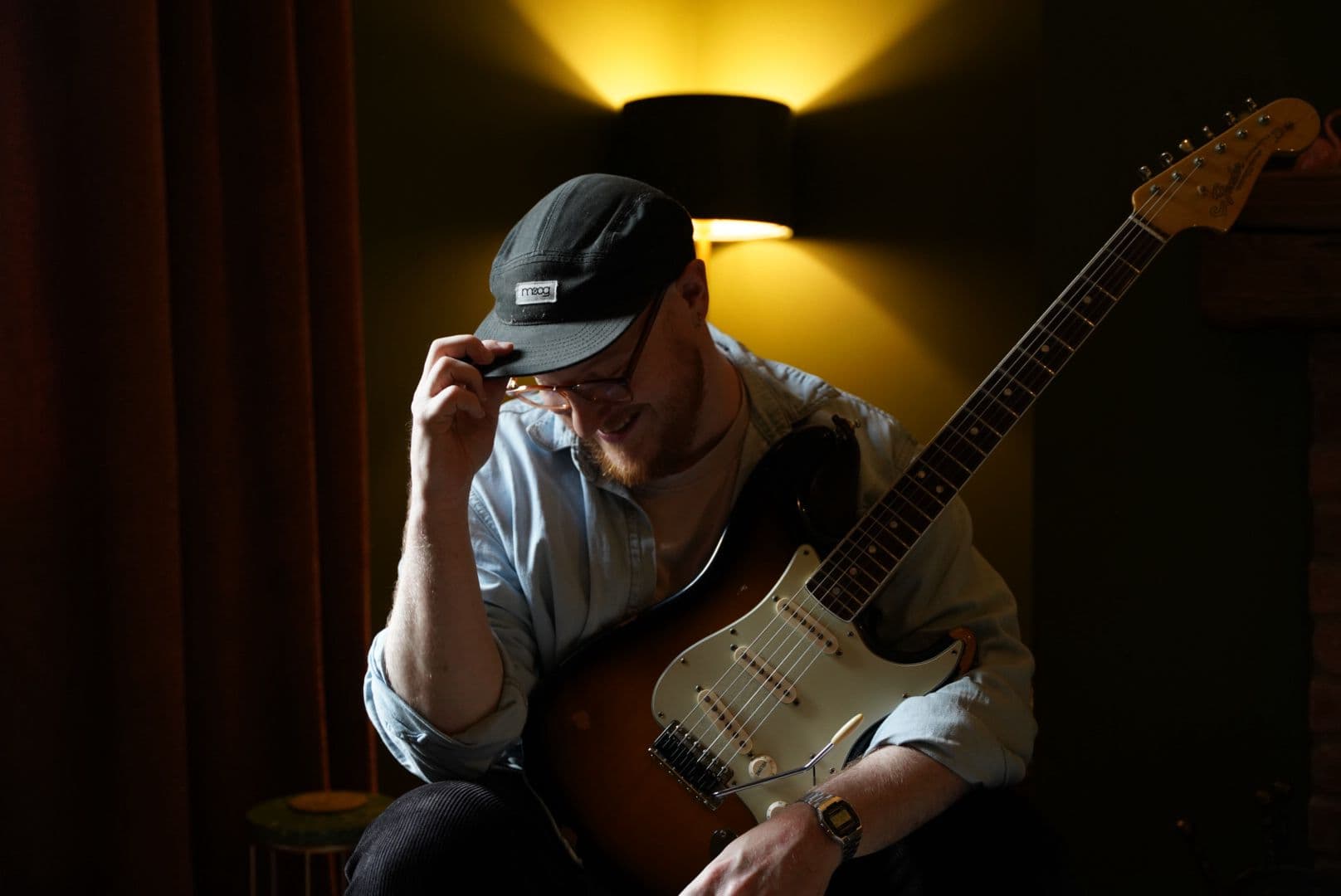 Sitting with a Stratocaster in warm lamp light