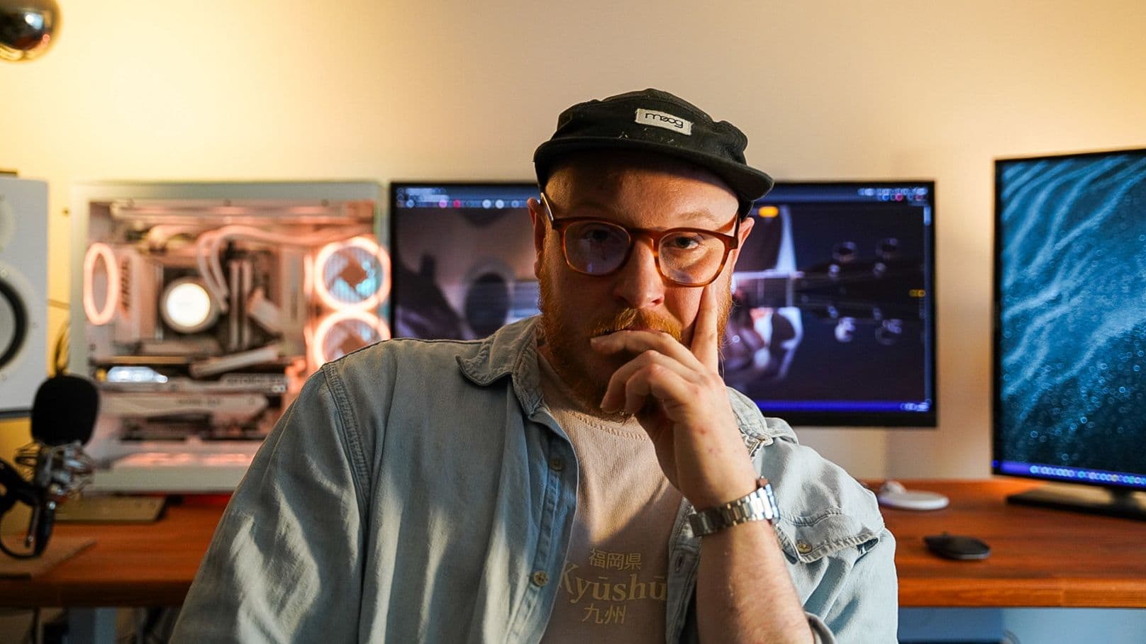 Chris Hall at his studio desk, with monitors and instruments behind him