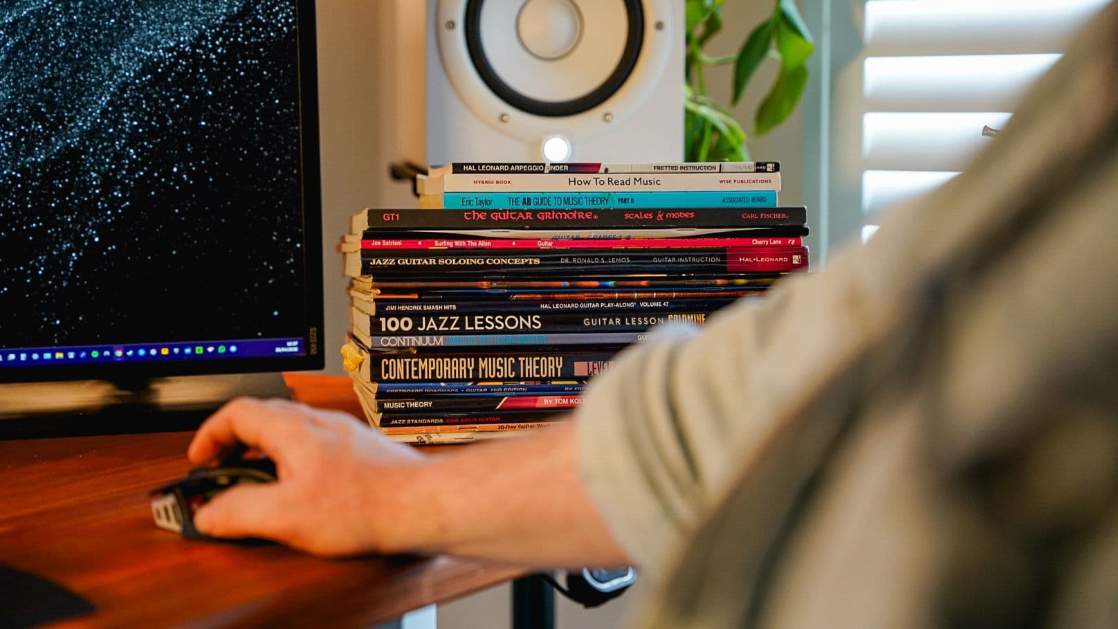 Stack of music theory books on a workstation